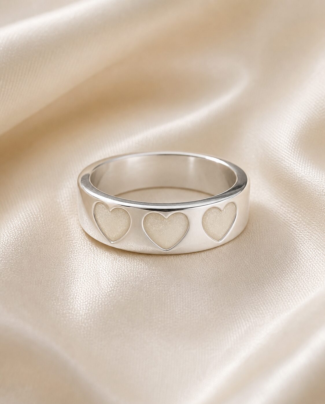 Anillo Tres Corazones de plata 925 con leche materna sobre tela satinada